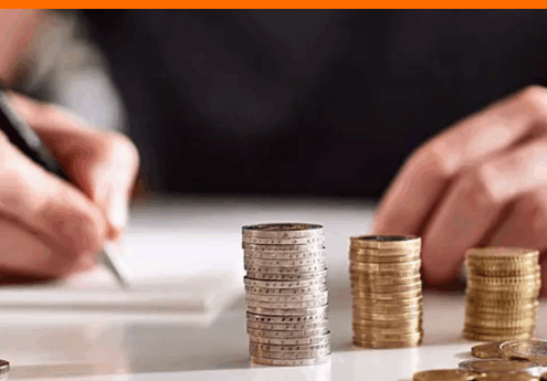 Stromanbieter Wechsel: Person notiert sich wichtige Informationen zur Optimierung ihrer Stromkosten, Münzstapel symbolisieren Einsparpotenzial.