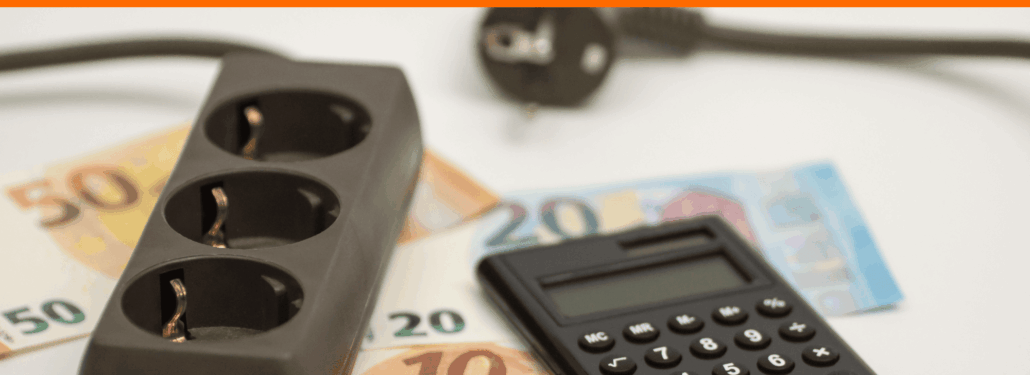 Steckdosenleiste, Taschenrechner und Euro-Scheine als Symbol für Strompreise und die Strompreisbremse 2026