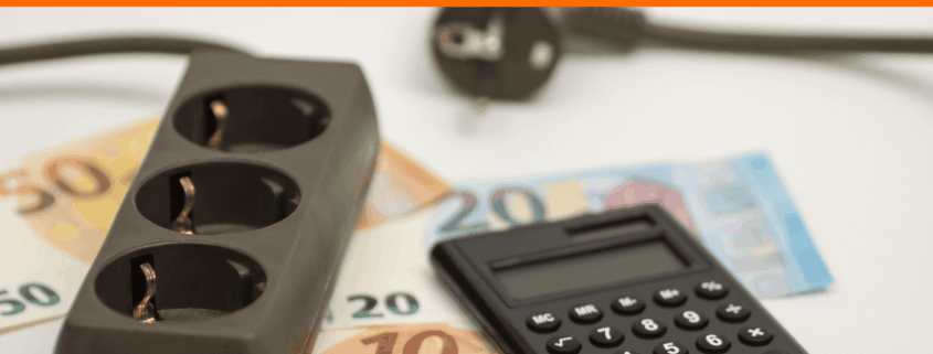 Steckdosenleiste, Taschenrechner und Euro-Scheine als Symbol für Strompreise und die Strompreisbremse 2026